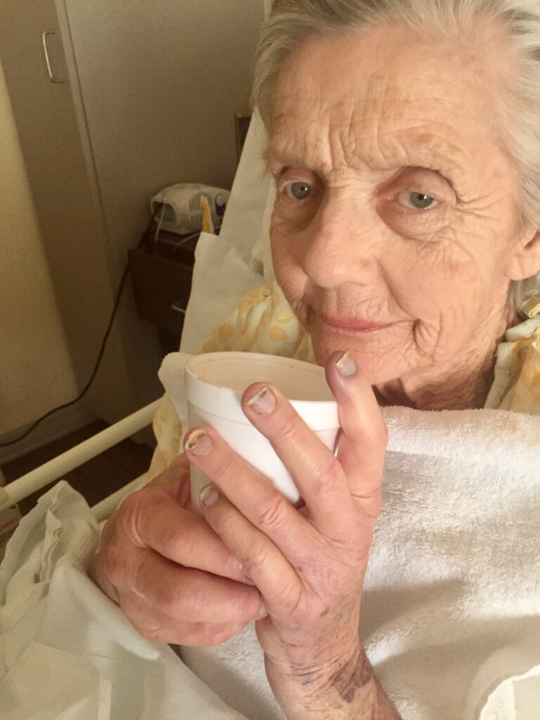 mother is hospice holding a styrofoam cup of coffee